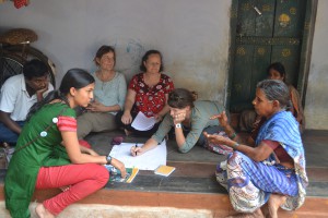 The newborn temperature monitoring team converses with a health auxiliary worker.